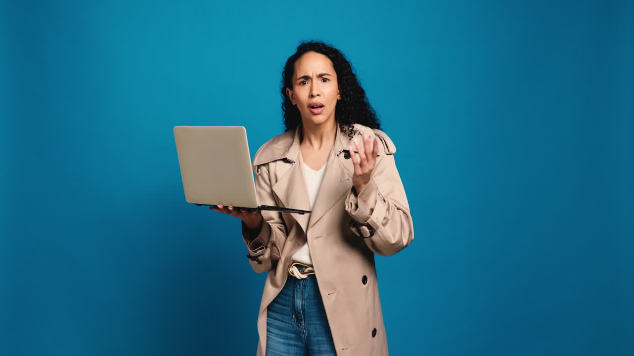 Worried woman with laptop on blue background