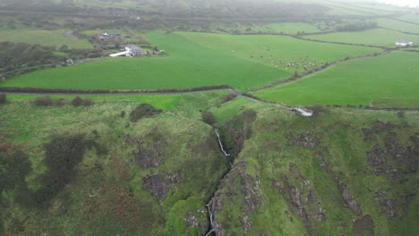 toma panorámica aérea de hermosos acantilados rocosos con paisajes verdes en los acantilados de gobbins mientras pasa por irlanda del norte en una mañana fresca