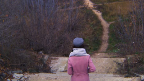 woman walking up steps in a forest