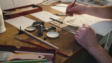 middle aged artist painting with a brush, camera moving, close