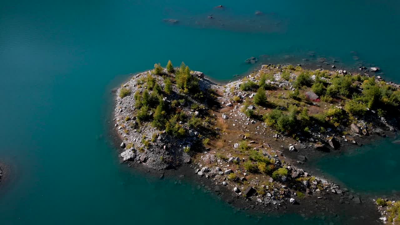 스위스 알프스 산맥의 은 가을 날, 스위스 발레에 있는 lac-de-salonne 해역의 섬 위를 날아다니며 주변의 알프스 봉우리와 절벽을 한눈에 볼 수 있습니다.