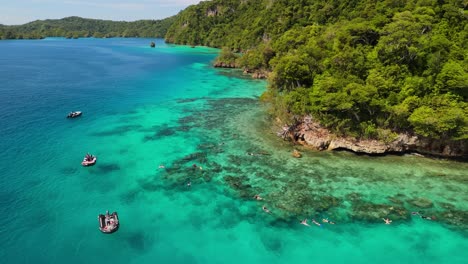 drone flying above snorkelers in fiji along coral reef