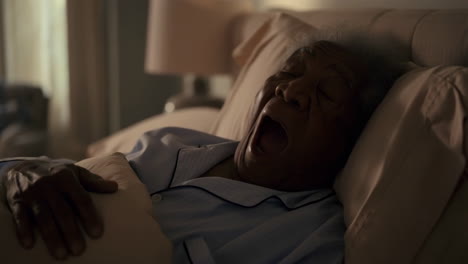 man sleeping and yawning in bed