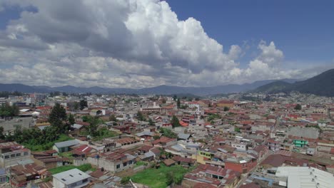 drone aerial footage of central american urban colonial city of quetzaltenango, xela, guatemala showing beautiful cityscape with colorful rooftops