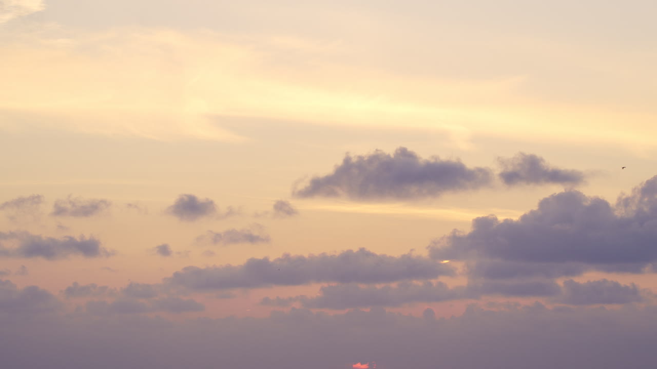 Beautiful soft sunset colors reflected on the ocean with calm waters and a serene sky in Estonia