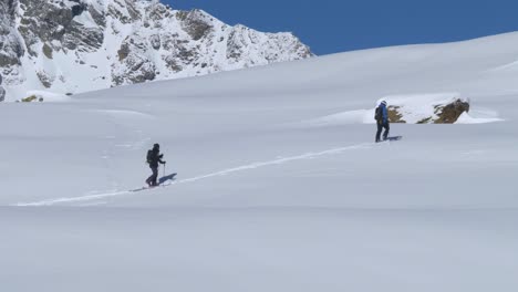 兩個滑雪徒步旅行者,在高山步道上在深雪中徒步旅行,明亮的冬天在阿爾卑斯山 - 靜態拍攝