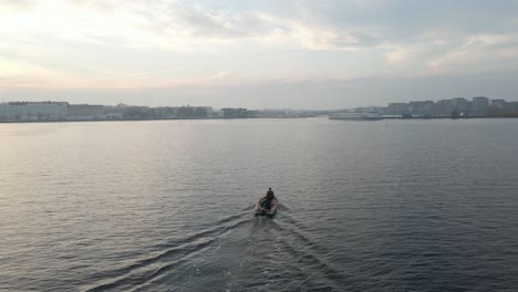 Two-fishermen-sitting-in-their-boating-on-their-way-to-Karlskrona,-Sweden-on-a-beautiful-cloudy-day-close-to-sunset-1