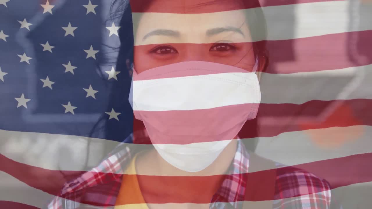 길거리에서 얼굴 마스크를 쓴 아시아 여성의 초상화에 대항하여 미국 국기를 흔들고 있습니다.