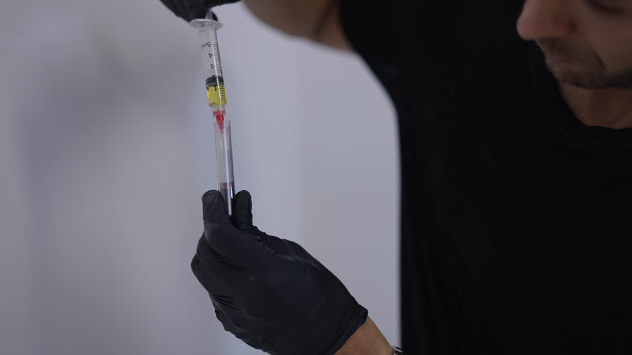 Medical Professional Prepares Blood Sample with Syringe and Test Tube