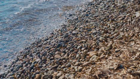 waves of a mediterranean pebble beach with turquoise water