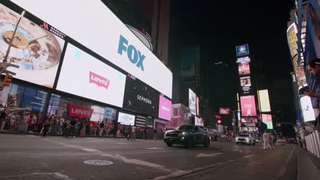 night traffic in times square with bright billboards and busy streets in new york city