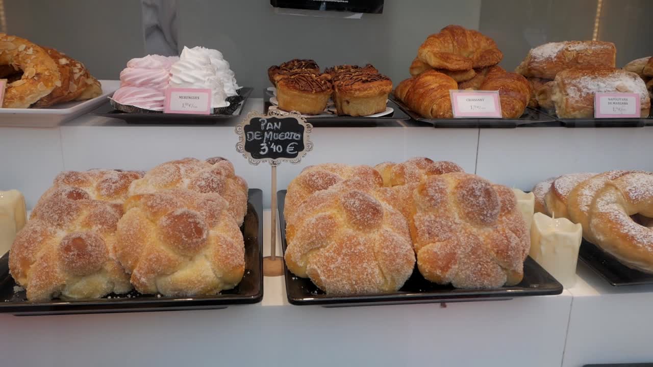 Patisserie display various pastries and biscuits for Halloween on window shop, including Pan de Muerto.