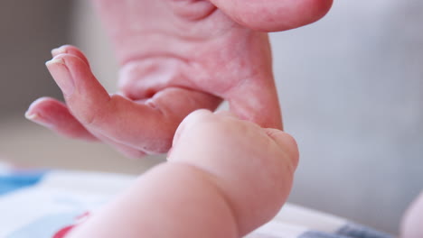 slow motion close up shot baby boy holding mothers finger