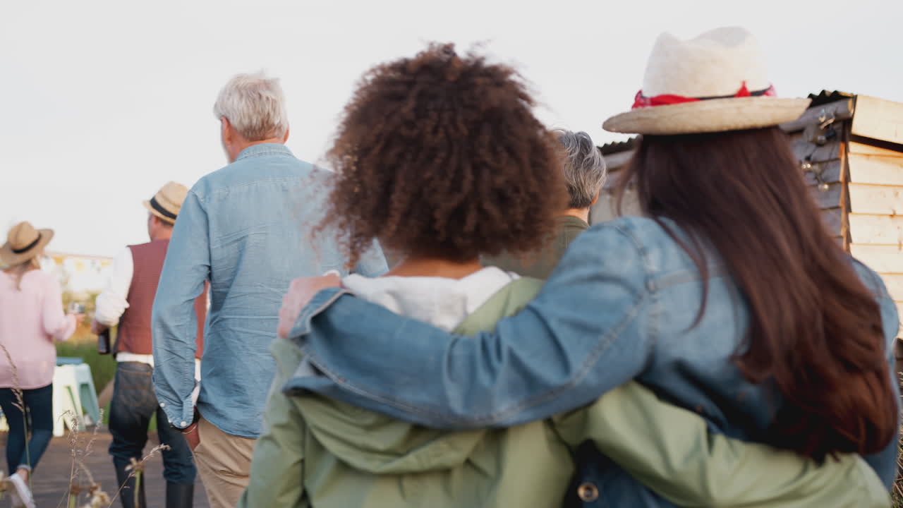 vista trasera de amigos maduros caminando por el camino a través del campamento