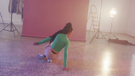 Portrait-of-biracial-female-dancer-dancing-in-dance-studio,-slow-motion