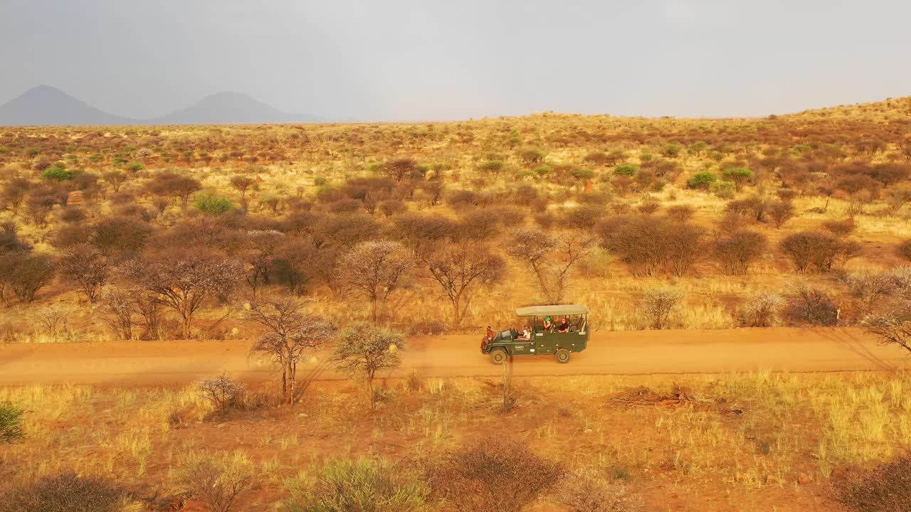 antena de un jeep safari que viaja por las llanuras de áfrica en la reserva de caza de erindi namibia con un guía de observación tribal nativo de san sentado en el frente observando la vida silvestre 1