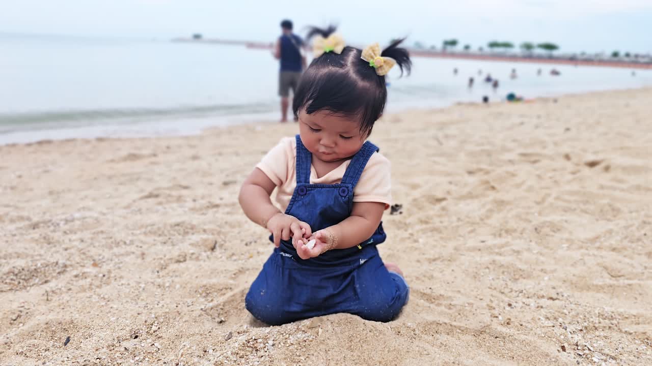 A toddler enjoys playing with sand a beach capturing the essence of childhood exploration and joy.