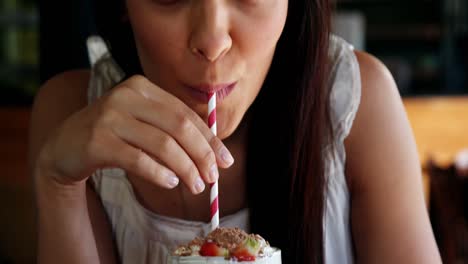 beautiful woman drinking smoothie with straw