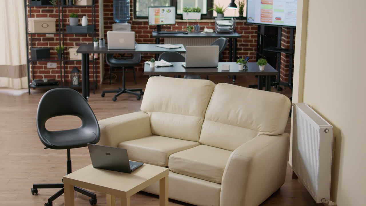 No people in empty workplace with couch and computers