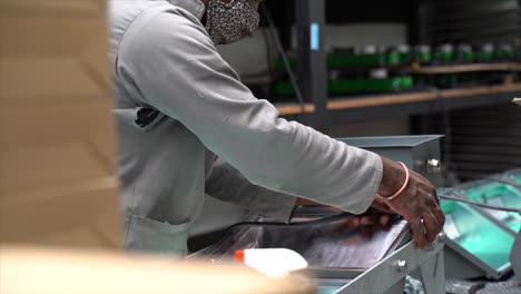 black factory employee wearing a mask fixing waterproof seal to an led light