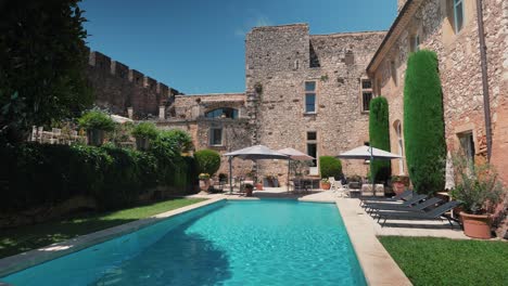 slow establishing shot of a private pool in the garden of chateau de pouzilhac