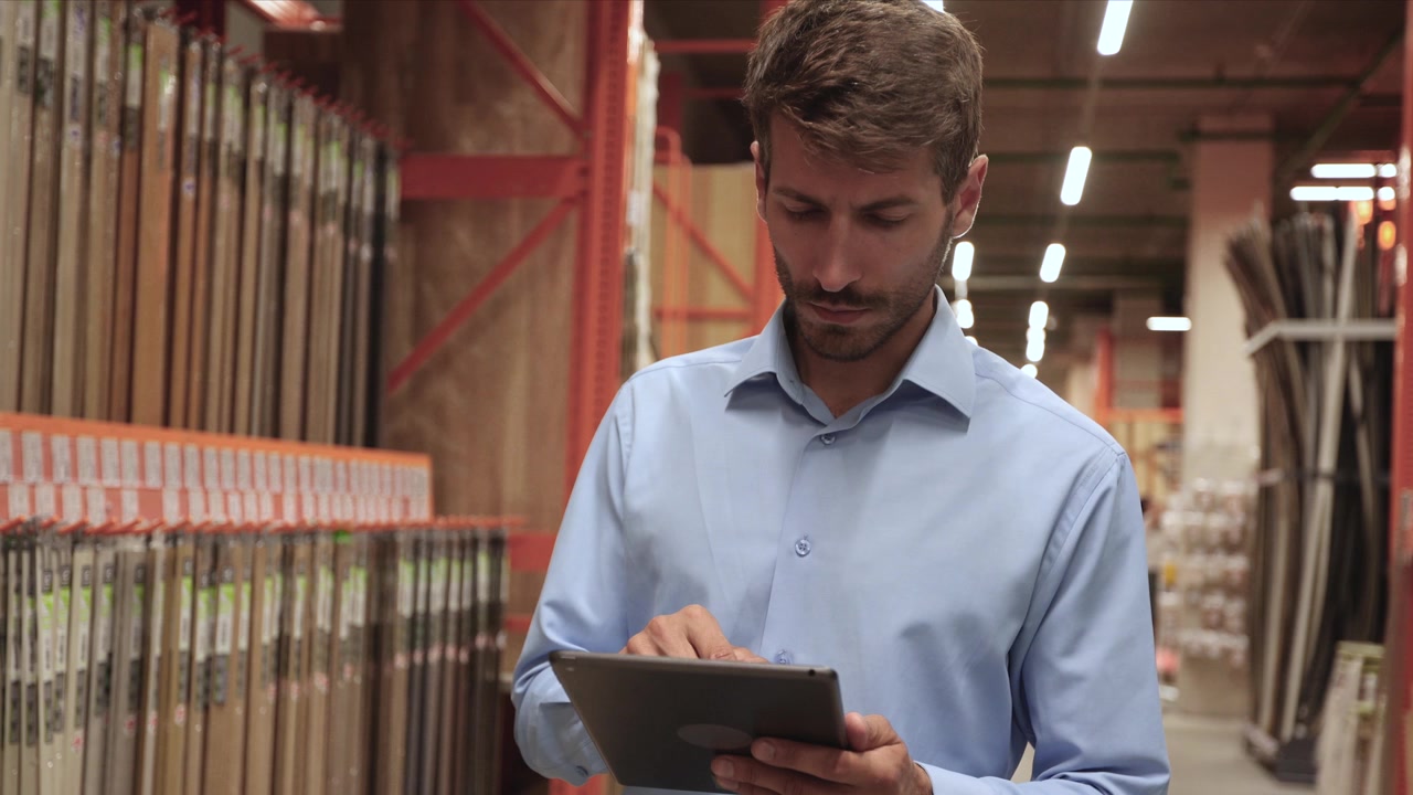 Hombre usando una tablet para revisar el inventario en una ferretería