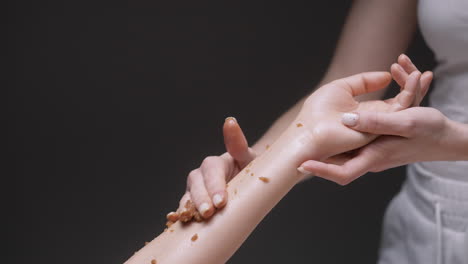 mujer recibiendo un masaje de exfoliante de azúcar
