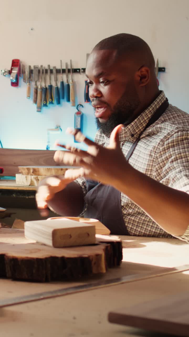 Happy Carpenter Talking and Gesturing in His Woodworking Workshop