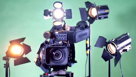 professional video camera is turning with several lighting plants on the background