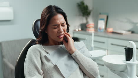 woman suffering from a toothache in a dental office