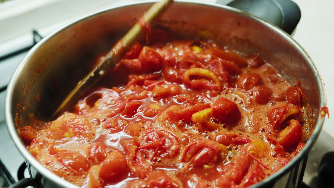 Cucinare cibo siciliano: pomodori spellati in una pentola