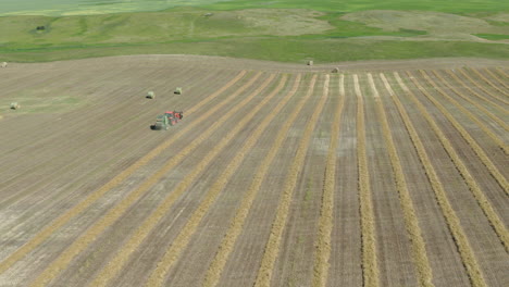 Wide-angle-aerial-shot-of-tractor-baling-rows-of-hay