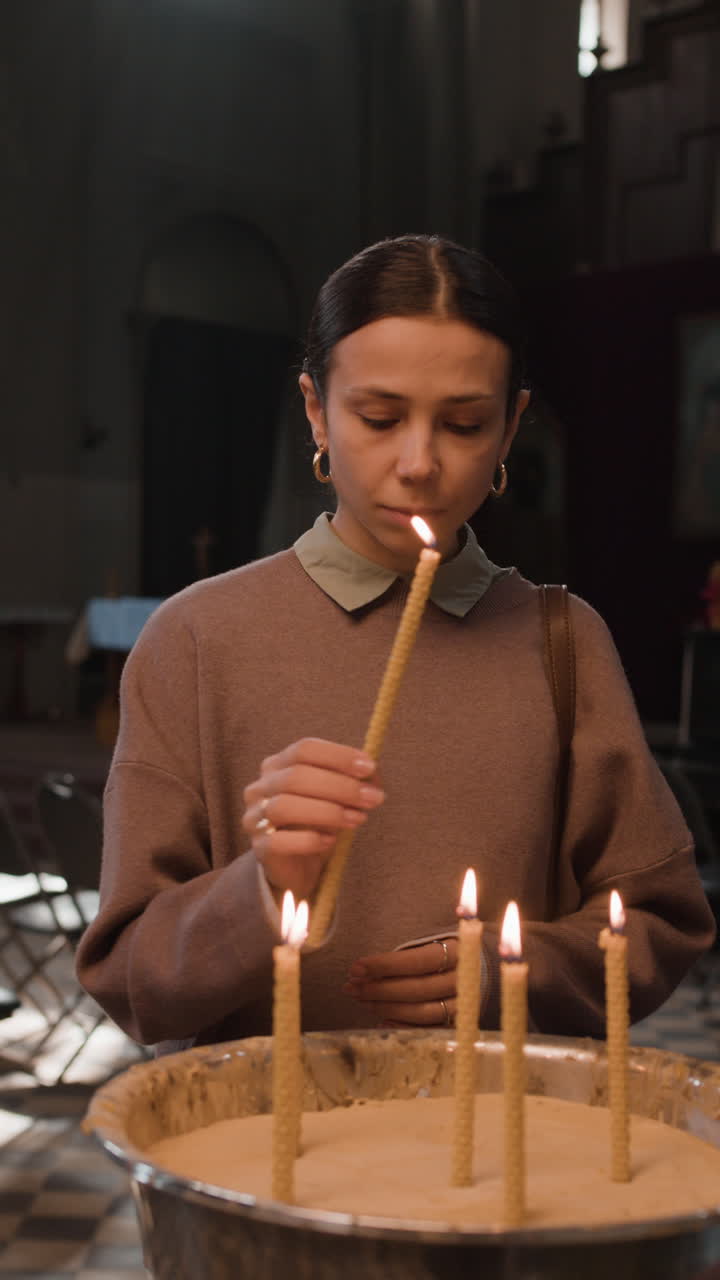 Woman Lighting Candles in Church