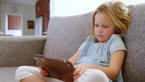 girl using digital tablet in living room 4k