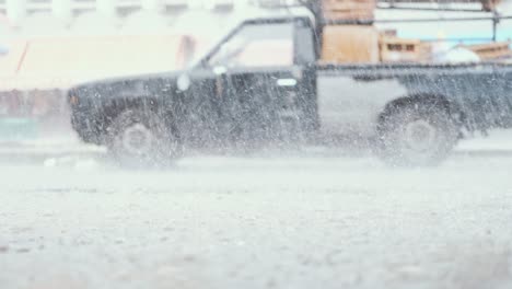side-view of a loaded, old truck in severe weather rain