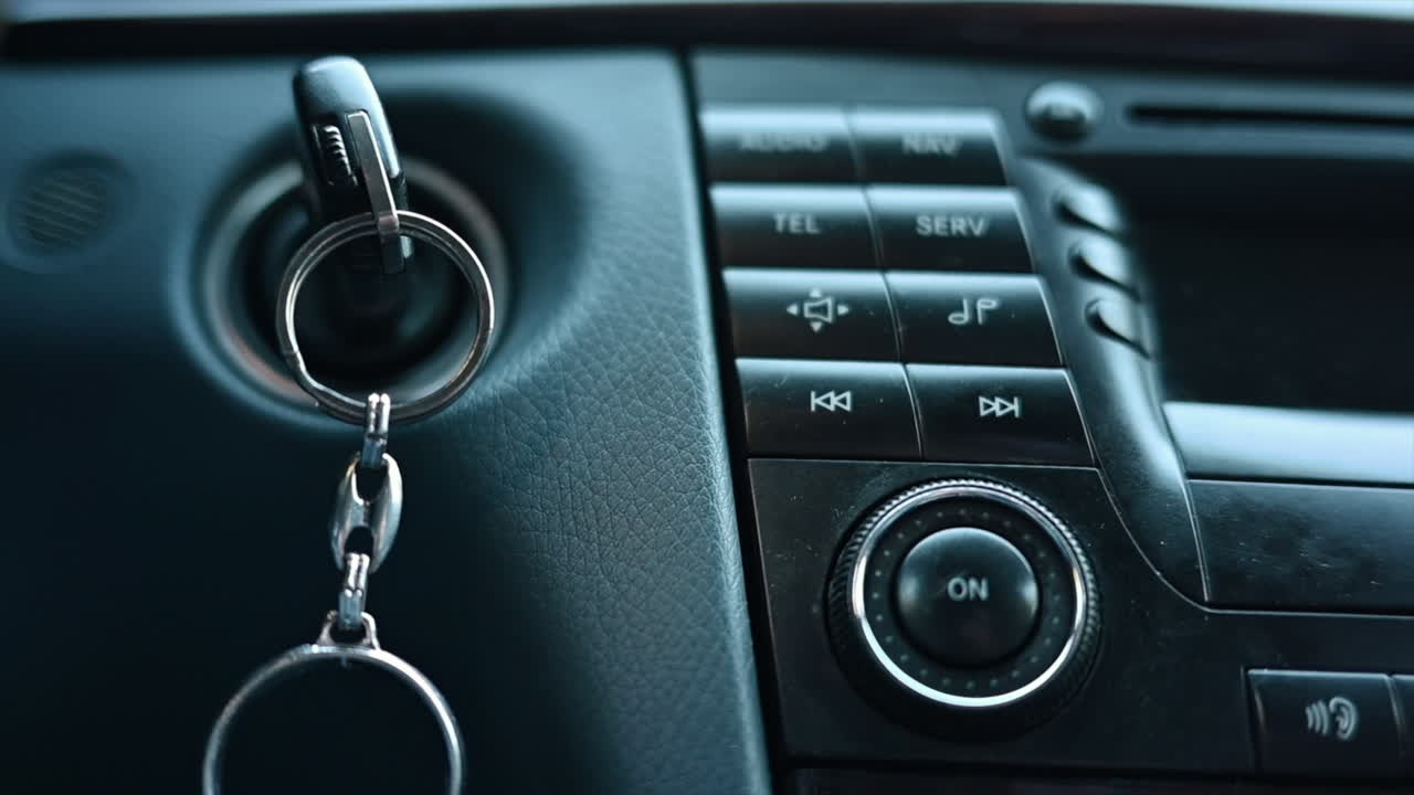 Close up of car keys in ignition with music player display board