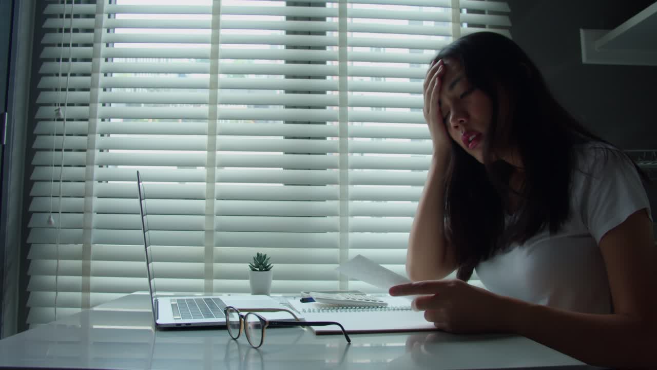 아시안 여성은 월간 가정 비용, 세금, 신용 카드 청구서 지불 및 은행 계좌 잔액을 계산하는 데 충분하지 않습니다.