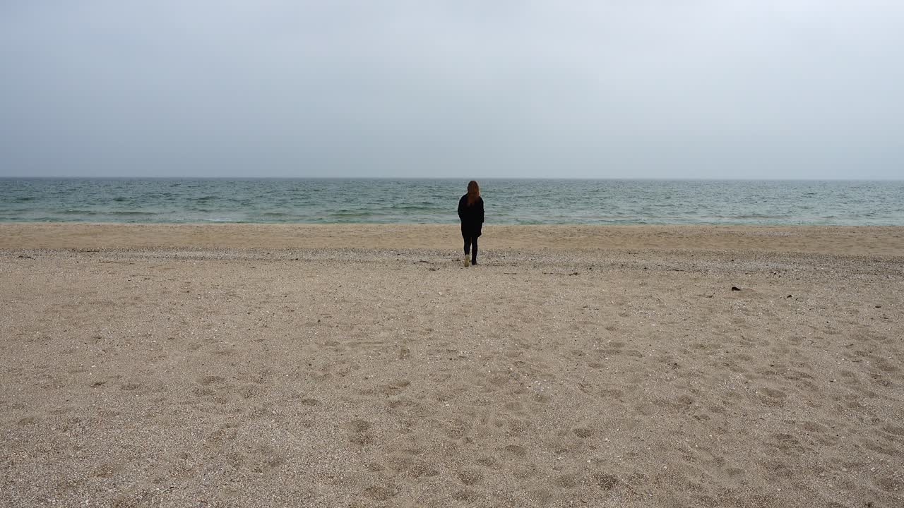 La chica camina por la playa. Rodaje en la playa.