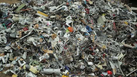 pile of mixed electronic waste and scrap materials in a recycling facility