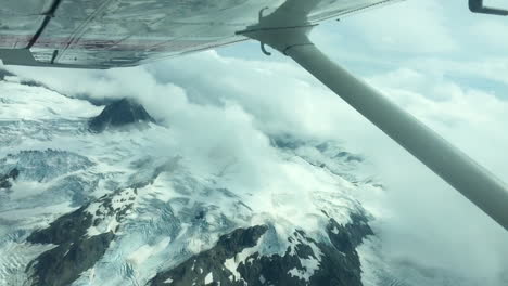 view from a plane of the top of snowy mountains in alaska