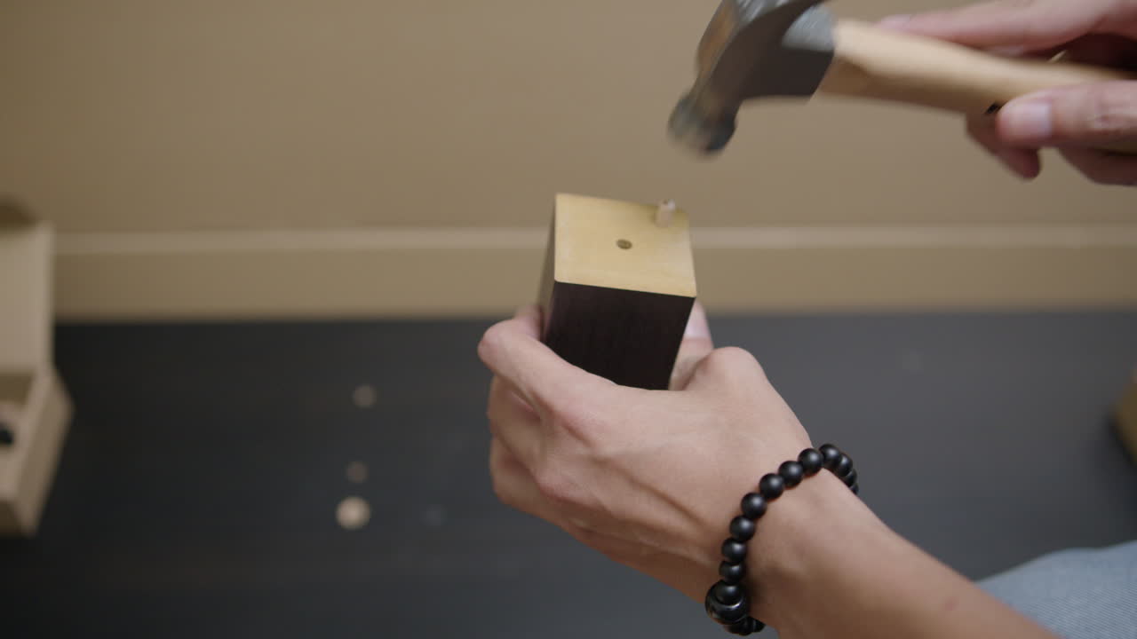 el hombre usa un martillo en una pieza de madera