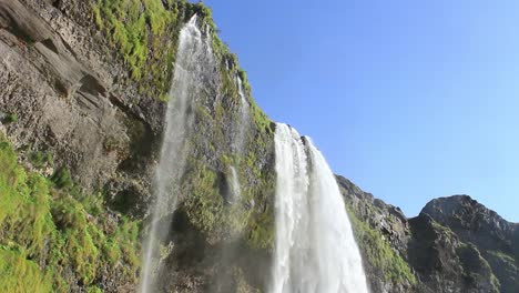 icelandic waterfall, famous tourist attraction, a view at the top of cascade where it burst out from the top of the mountain, seljalandsfoss in south iceland