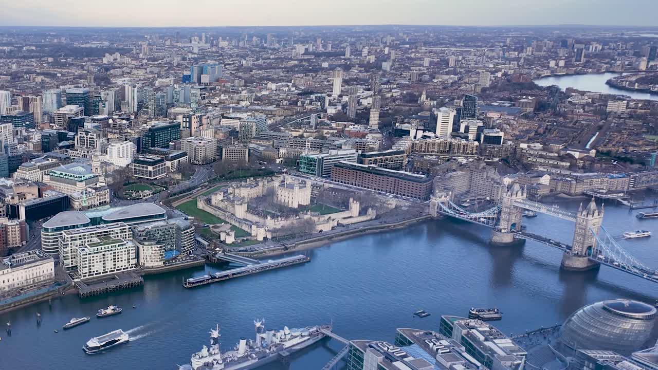 Timelapse of Tower Bridge in London, with traffic and pedestrians moving through the iconic landmark as ferries cross and depart from pier, high angle overview