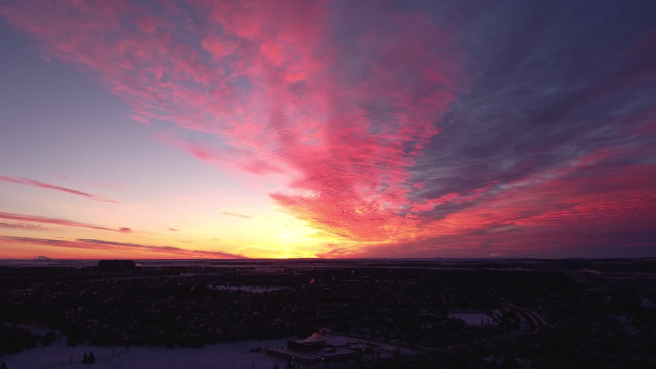 tomas aéreas de la comunidad de calgary durante un hermoso amanecer de invierno con rayos de dios