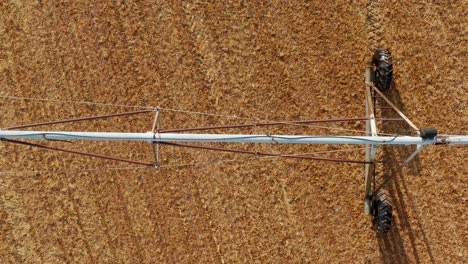 la antena estática revela la pulverización de agua nebulizada desde el equipo de riego en un campo marrón