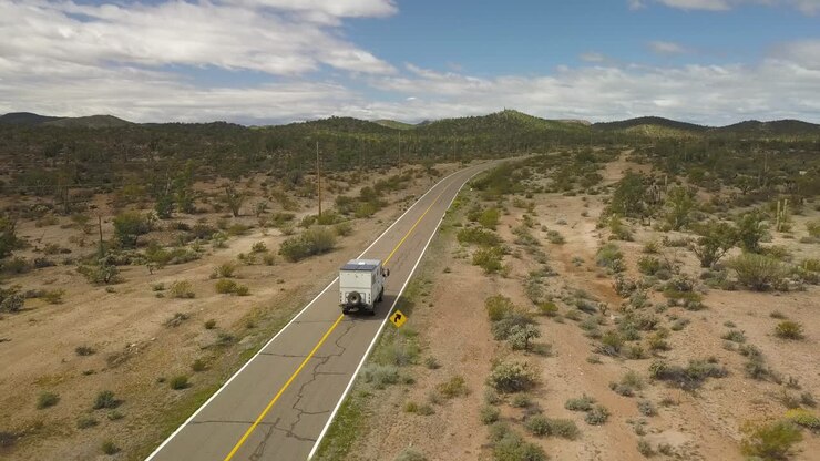 grande camper che appare in basso a sinistra dell'inquadratura che guida attraverso le strade deserte deserte della baja california