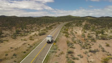 gran autocaravana que aparece en la parte inferior izquierda de la toma conduciendo por las carreteras vacías del desierto de baja california