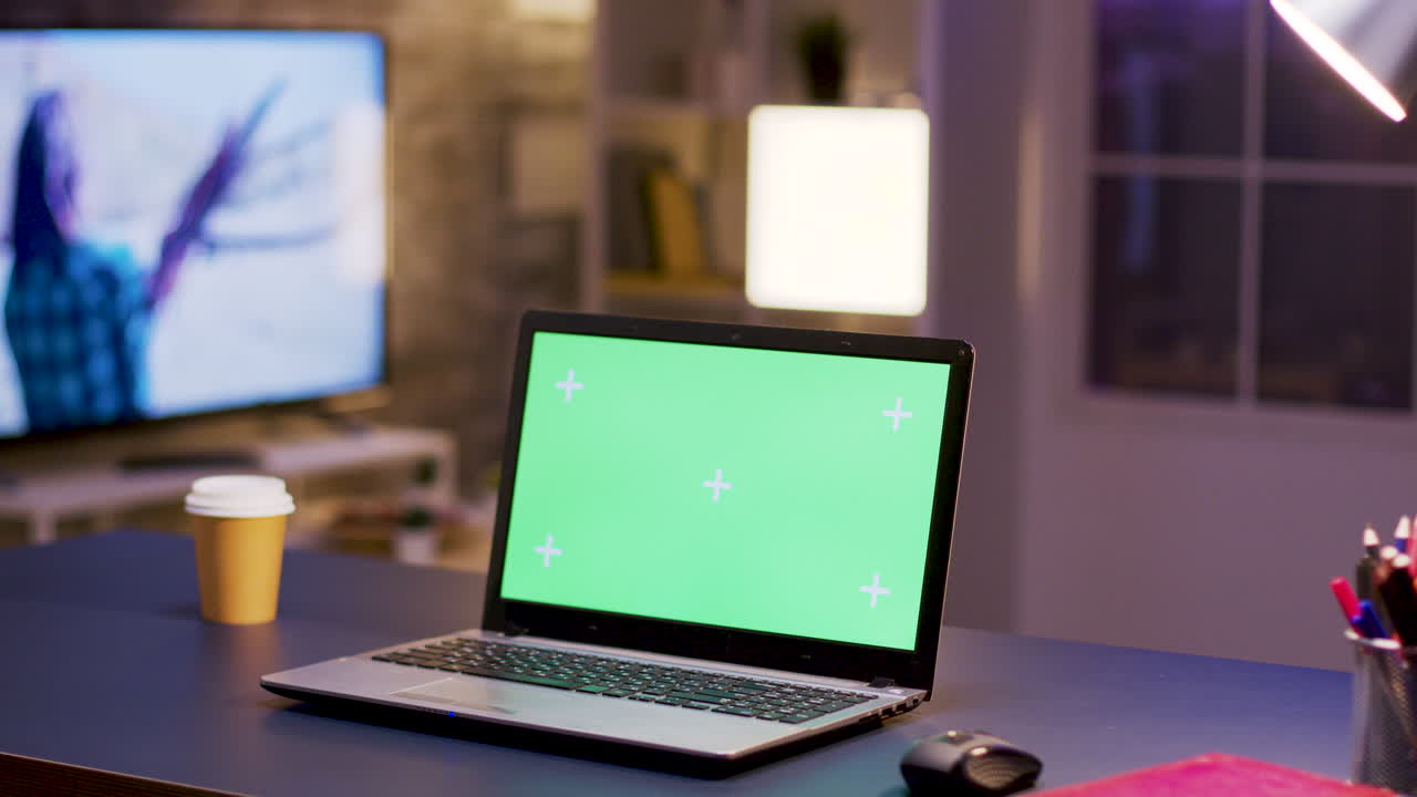 portátil con pantalla verde en un escritorio