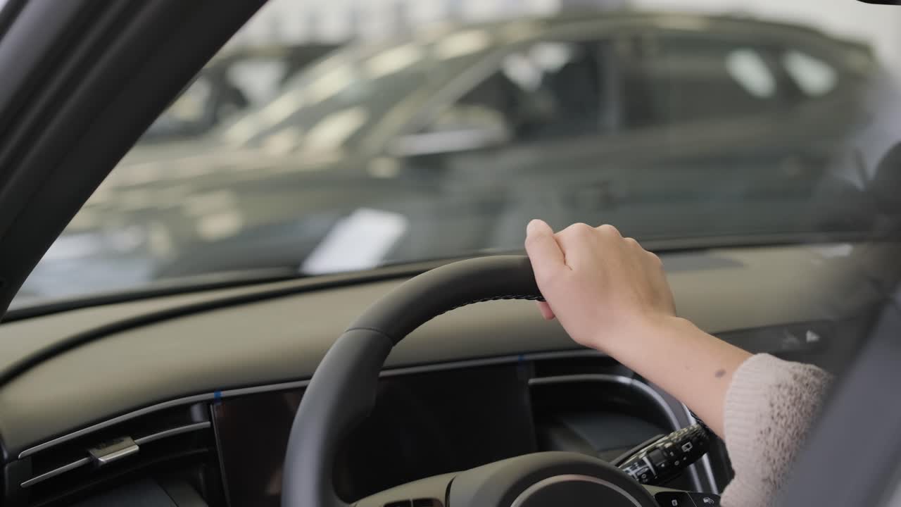 여자 가 자동차 전시실 에서 자동차 를 선택 하고 있다