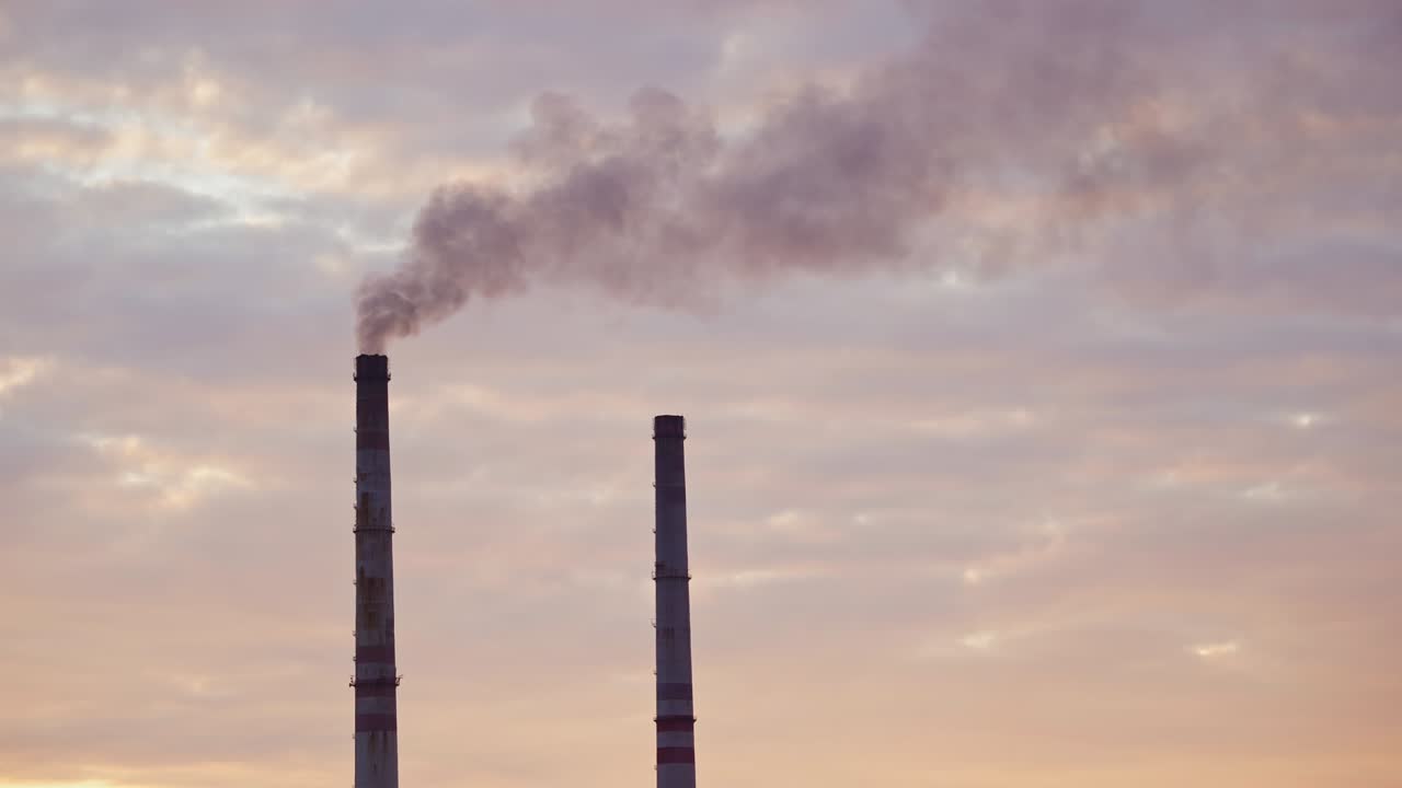 i camini alti degli impianti industriali fumano sullo sfondo della natura e del fiume. i camini sporchi delle fabbriche soffiano enormi fumi nell'aria. l'avvelenamento ambientale da parte dell'industria chimica.